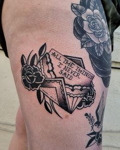 a tattoo on the thigh of a man with flowers and an old - fashioned cross