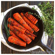 cooked carrots in a cast iron skillet with herbs