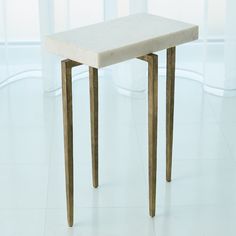 a small white table sitting on top of a tiled floor