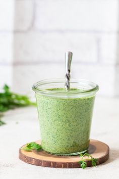 a green smoothie in a glass container with a straw sticking out of the top