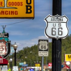 several signs are posted on the side of a pole in front of a gas station