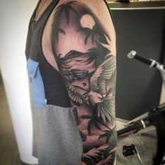 a man's half sleeve with an eagle and palm trees on the left arm