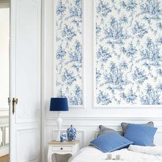 a bedroom with blue and white wallpaper on the walls