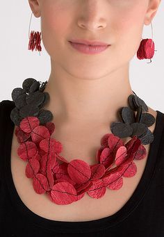 a woman wearing a red and black necklace with flower decorations on it's neck