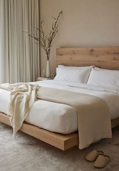 a bed with white sheets and pillows next to a window