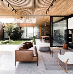 a living room filled with furniture and a wooden ceiling