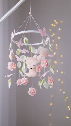 a pink teddy bear mobile hanging from the ceiling with flowers and leaves on it's sides