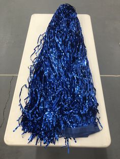 a table topped with blue tinsel next to a white plate filled with confetti