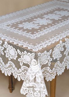 the table cloth is white and has lacy doily on it, with an intricate design