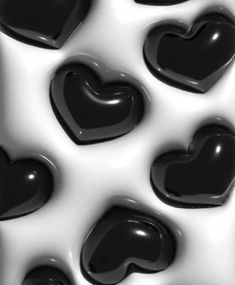 some black and white hearts are in the shape of an abstract pattern on a surface