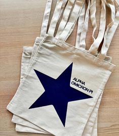 three bags with blue stars on them sitting on a wooden table next to each other