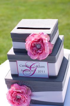 three books stacked on top of each other with pink flowers in the middle and one book sitting on top of them