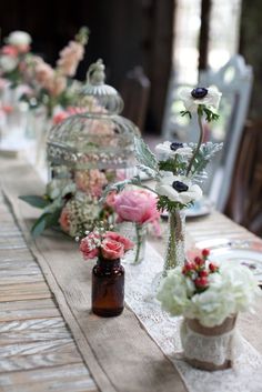 there are many vases with flowers on the table