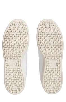 a pair of white slippers on top of each other with holes in the sole