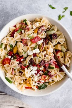 a white bowl filled with pasta and vegetables