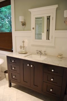 a bathroom with two sinks and a large mirror above the sink is in front of a window