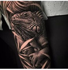 a man's arm with a lizard and leaves tattoo on the left side of his arm