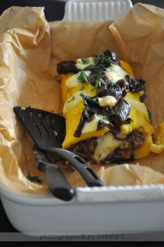 a close up of food in a container with utensils