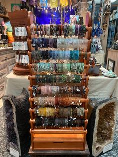 an assortment of bracelets are on display in a jewelry store with other items behind it