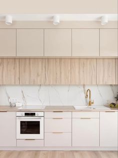 a kitchen with white cabinets and marble counter tops, along with an oven in the center