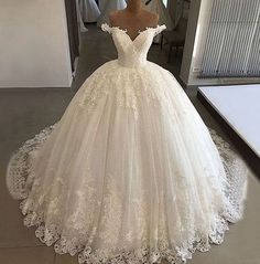 a wedding dress on display in front of a mirror