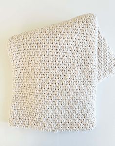 a white crocheted pillow on top of a table