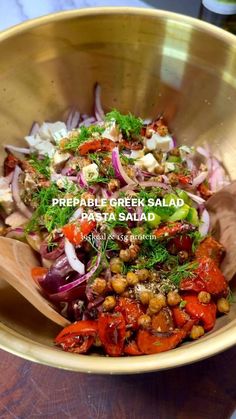 a salad in a gold bowl on top of a wooden table with the words prebable greek salad