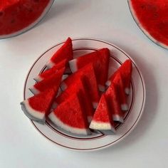 slices of watermelon sit on a plate next to another piece of fruit that has been cut into smaller pieces