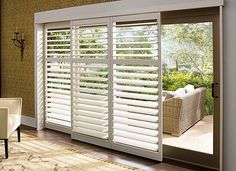 the interior of a living room with white shutters