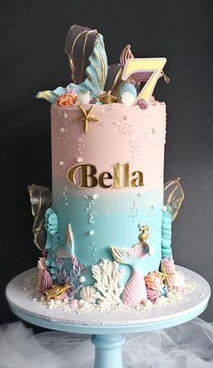 a pink and blue cake with sea animals on it's side, sitting on top of a table