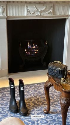 two black boots sitting in front of a fire place