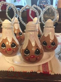 three glass vases sitting on top of a white plate covered in frosted decorations