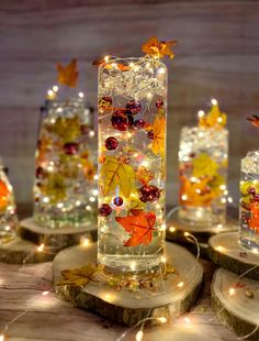 lighted glass vases with autumn leaves on them