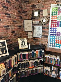 a room filled with lots of books next to a brick wall