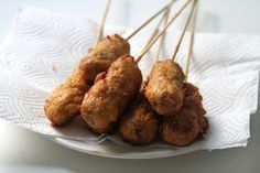 several skewers of food sitting on top of a white paper towel with toothpicks sticking out of it