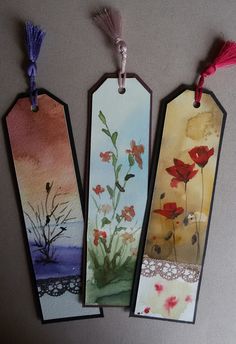 three tags with flowers painted on them are hanging from the wall next to each other