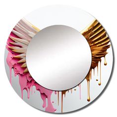 a round mirror with pink and gold paint dripping on the surface, in front of a white background