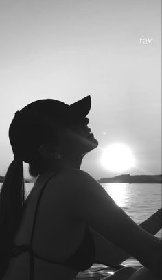 a woman sitting on top of a boat near the ocean