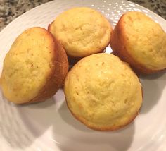 three yellow muffins on a white plate