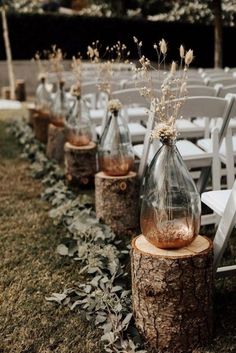 an image of a wedding ceremony with flowers in vases on the side of a tree stump