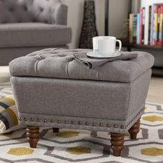 a gray ottoman with a coffee cup on it