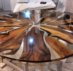 a wooden table with glass top in the shape of an abstract flower on it's side