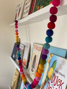 there are many books on the shelves with colorful beads hanging from them