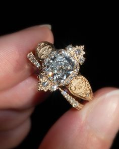 a close up of a person's hand holding a ring with diamonds on it