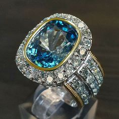 a blue and white ring sitting on top of a glass display case in front of a wooden table