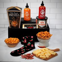 various snacks and condiments are arranged on a counter top, including hot sauces