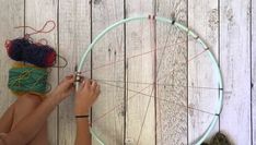 a woman is working on a project with yarn and scissors in front of a spinning wheel