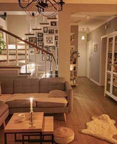 a living room filled with furniture and a chandelier hanging from the ceiling over a wooden floor