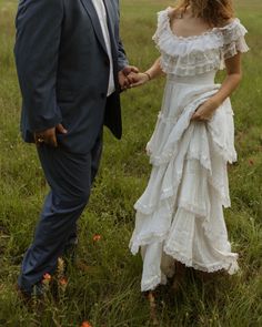 a man and woman standing next to each other in a field