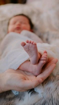 a newborn baby is being held by someone's hands